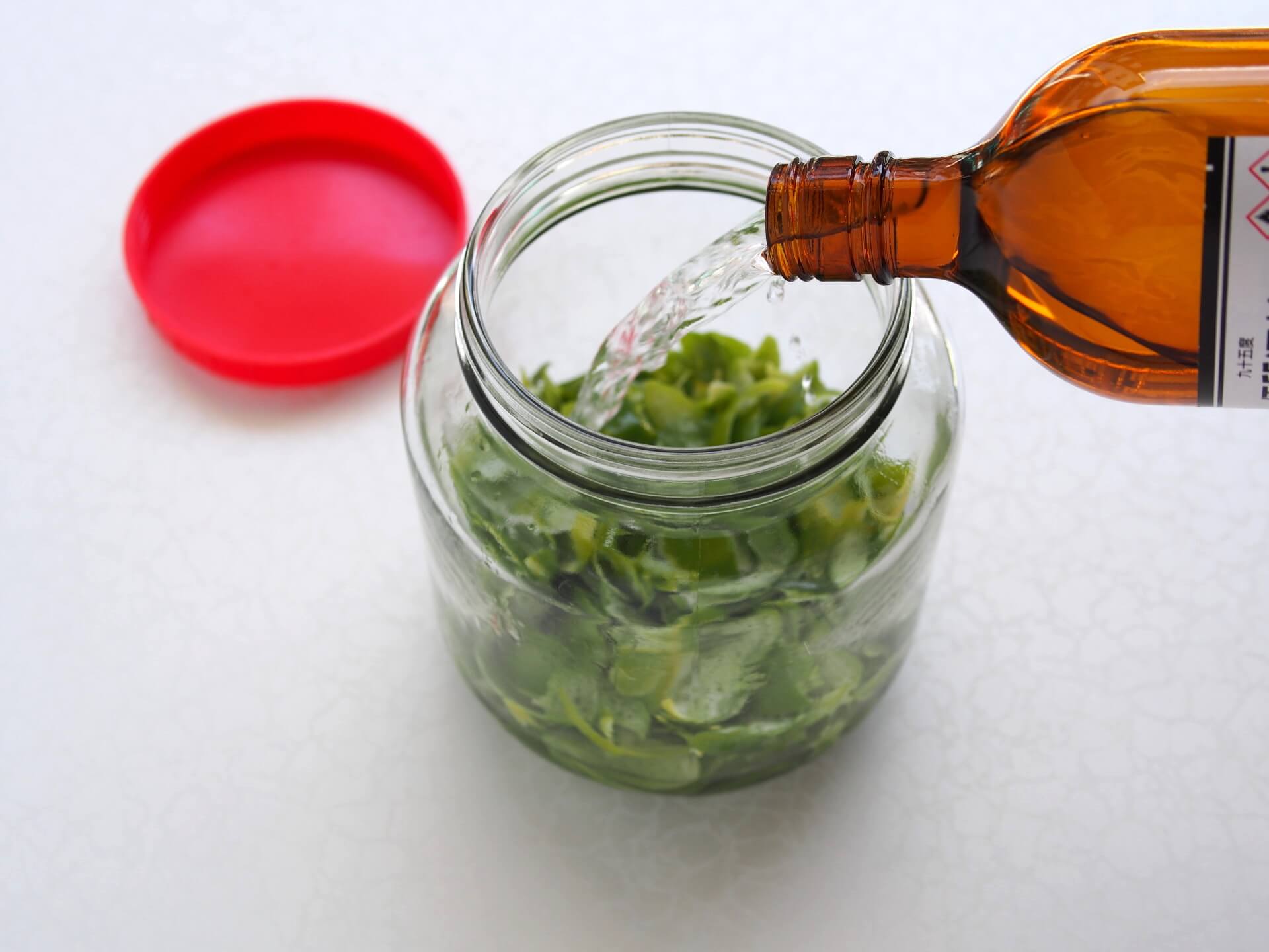 將酒精倒入玻璃罐中